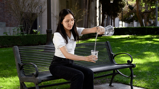 Girl pouring something in a beaker